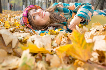 Happy autumn travel woman. Beautiful woman wearing bright clothes with yellow suitcase