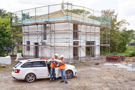 Bauleitung und Architekt Besprechung auf Baustelle Hausbau // construction manager and architect on site during the construction of a house - planning and control on site - teamwork