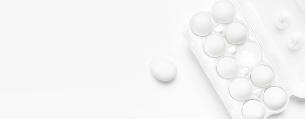 White chicken eggs in white packaging on light background top view flat lay copy space. Eggs in box, natural healthy food and organic farming concept. Creative food minimalistic background, Easter