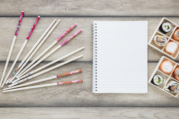 Flat lay sushi composition with notepad template