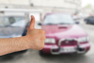 Man making thumb up gesture for car