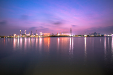Fototapeta premium The blurred background of nature along the river, with views of the cargo ship, oil refinery, sunrise and beautiful sky in the morning