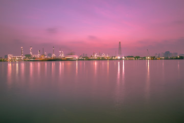 Fototapeta premium The blurred background of nature along the river, with views of the cargo ship, oil refinery, sunrise and beautiful sky in the morning