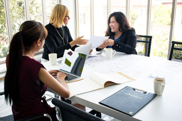 Female employees are offering jobs to the chief in the meeting room.