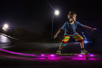 Kid skating with light in a night park