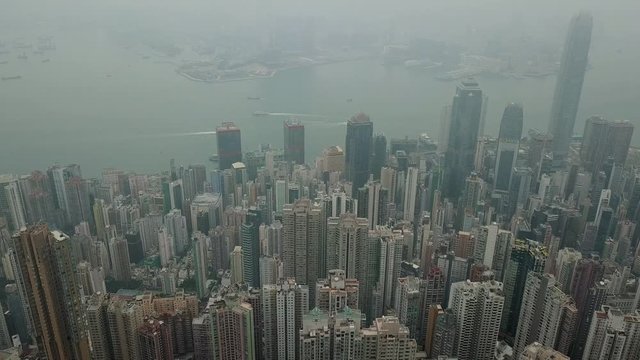 Aerial dolly out of foggy dramatic Hong Kong skyline and Victoria harbour