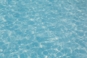 Blue pool water with sun reflection