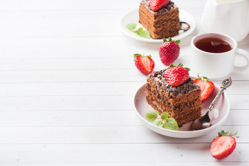 Truffle cake with chocolate and strawberries and mint on a white wooden table. Selective focus. Copy space