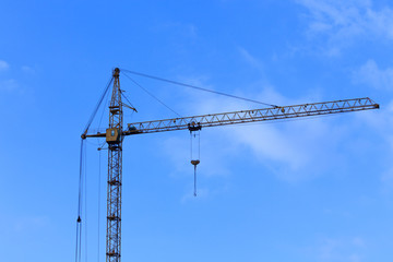 Construction crane against the blue sky background.
