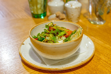 A plate with fresh, appetizing salad is on the table. Grilled vegetarian salad with pumpkin and asparagus. Full of vitamins food cooked with care for health and longevity.