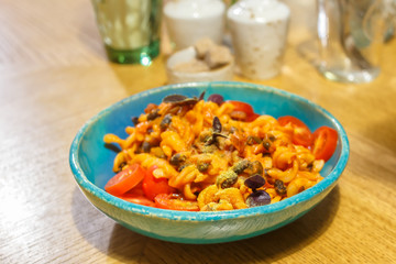 Vegetarian pasta with black beans basil, tomatoes and vegetable cheese. Soft focus.