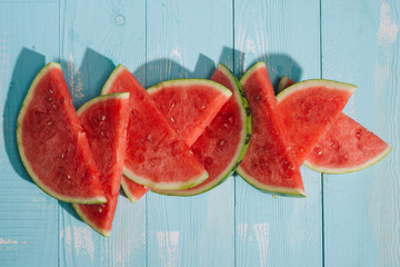 Slices of watermelon on blue wooden desk.