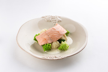 Steamed salmon, cauliflower and broccoli on white plate isolated on white background