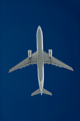 Naklejka na ściany i meble Verkehrsflugzeug mit zwei Turbinen in großer Höhe vor einem dunkelblauen Himmel.