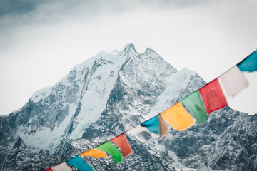 Everest trekking and hiking. Mountains of Nepal. Mountain in focus. Nepalese prayer flags are blurred. Adventure in the Himalayas