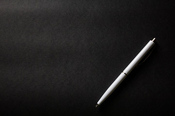 white pen on black background with copy space