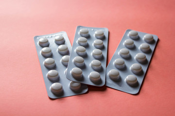 pills in blister on pink background with copyspace