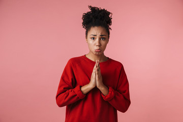 Obraz premium Sad african woman posing isolated over pink wall background make hopeful please gesture.