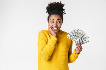 African excited emotional happy woman posing isolated over white wall background holding money.