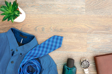 Flat lay with men's accessories on the corner. Copy space for father's day greeting text. Blue and brown colors