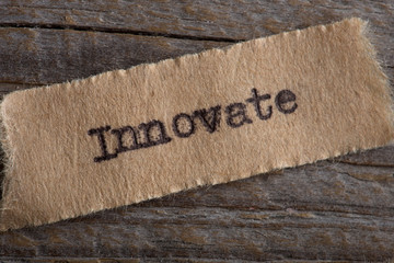 Innovate word on a piece of paper close up, business creative motivation concept