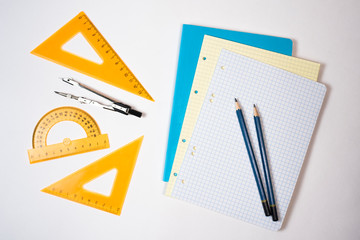 Back to school. Geometry. Ruler, compass, pencil and notebook on white background