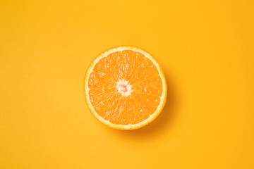 Half an orange on a yellow background