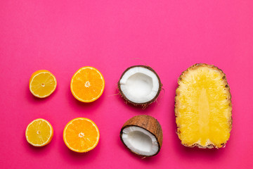 Summer fruits. Pineapples, coconuts on pink background.