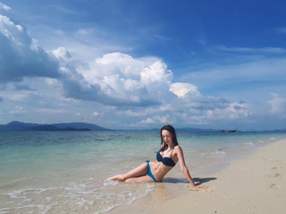 Fototapeta na wymiar Beautiful young woman on the beach of the tropical island