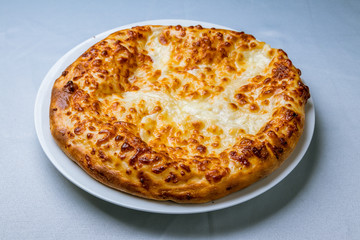 khachapuri with cheese on white plate
