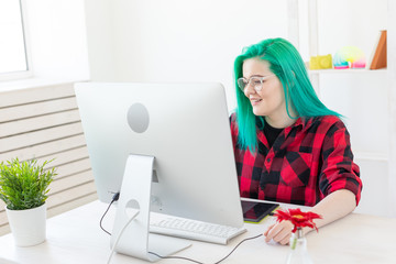 Business, designer and animator concept - young woman illustrator or artist with green hair draws...