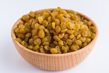 golden raisins on a white acrylic background