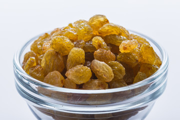 golden raisins on a white acrylic background