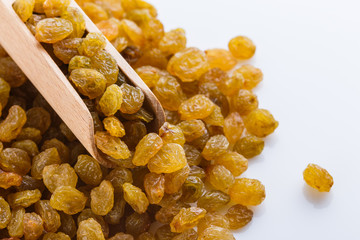 golden raisins on a white acrylic background