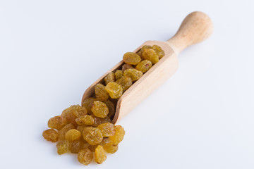 golden raisins on a white acrylic background