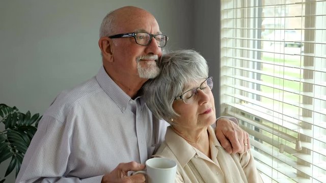 Senior aged couple smiling and looking out a window