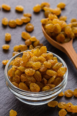 golden raisins on a dark stone background