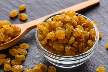 golden raisins on a dark stone background
