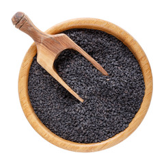 Black sesame seeds in wooden bowl isolated on white background. Top view.