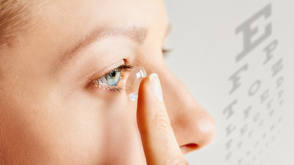 Young woman puts contact lens in her eye. Eyewear, eyesight and vision, eye care and health,...