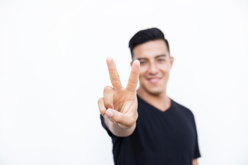 Handsome latin hispanic man is showing two fingers isolated on white background. Place for text and design.