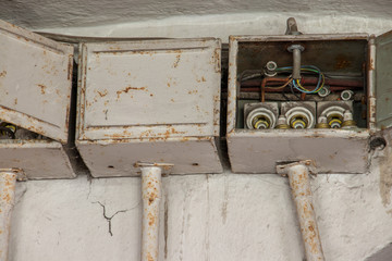 three old electrical boxes on wall