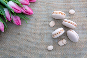 Mother's day background with tulips bouquet and pink macarons.