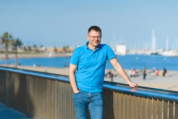 man standing at beach fence