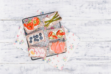 Snack sandwiches with different ingredients and flavor on a white wooden table. Top view. Free space for text.