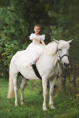 Obraz na płótnie Canvas happy little princess on white horse in the forest