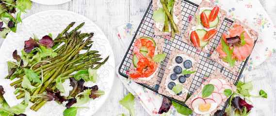 Summer snack sandwiches and asparagus, on a white wooden table. Top view. Free space for text. Banner