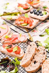 Summer snack sandwiches on a white wooden background with different compositions.