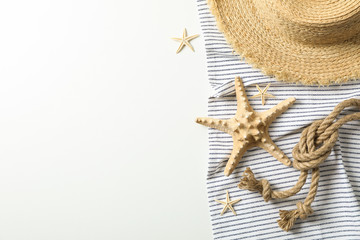 Fototapeta na wymiar Tablecloth with straw hat, starfishes and sea rope on white background, space for text and top view. Summer vacation