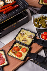 young woman is preparing a traditional Swiss cheese raclette